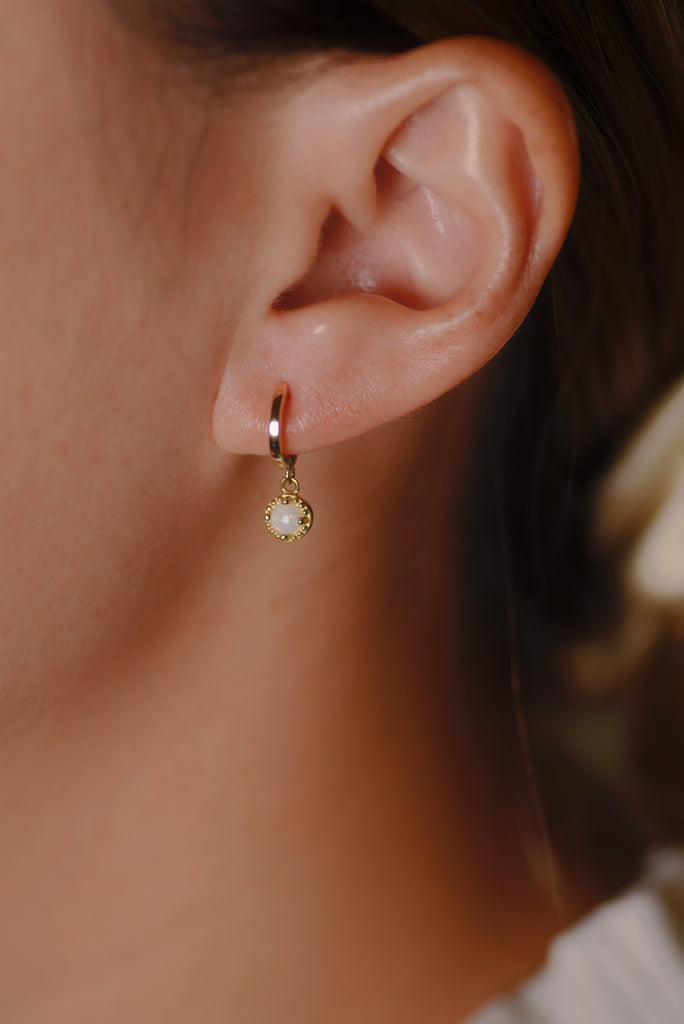 Model wearing Bliss Opal Drop Earrings in Yellow Gold, White