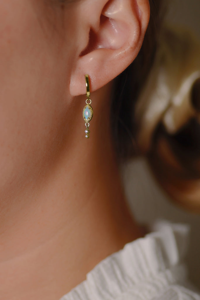 Model wearing Leaf Opal Drop Earrings with Diamonds in Yellow Gold, Blue