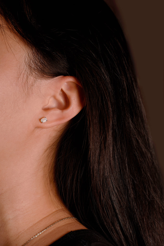 Model wearing Oval Opal Stud Earrings in Sterling Silver, White